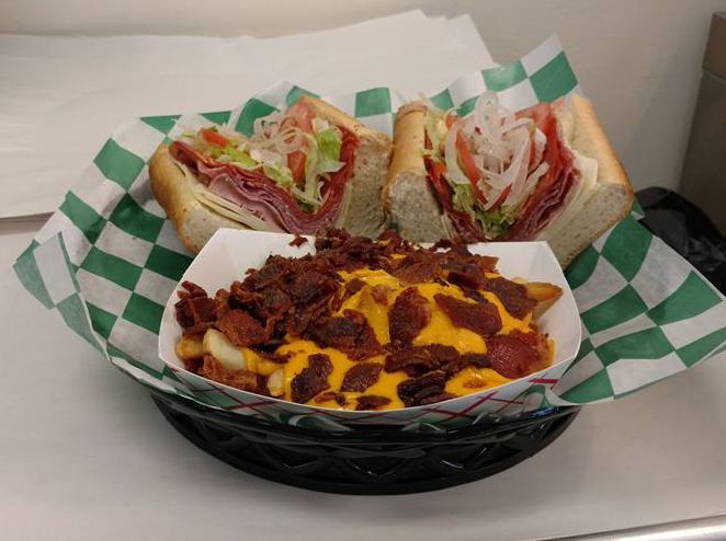 A sandwich and french fries in a basket on a table